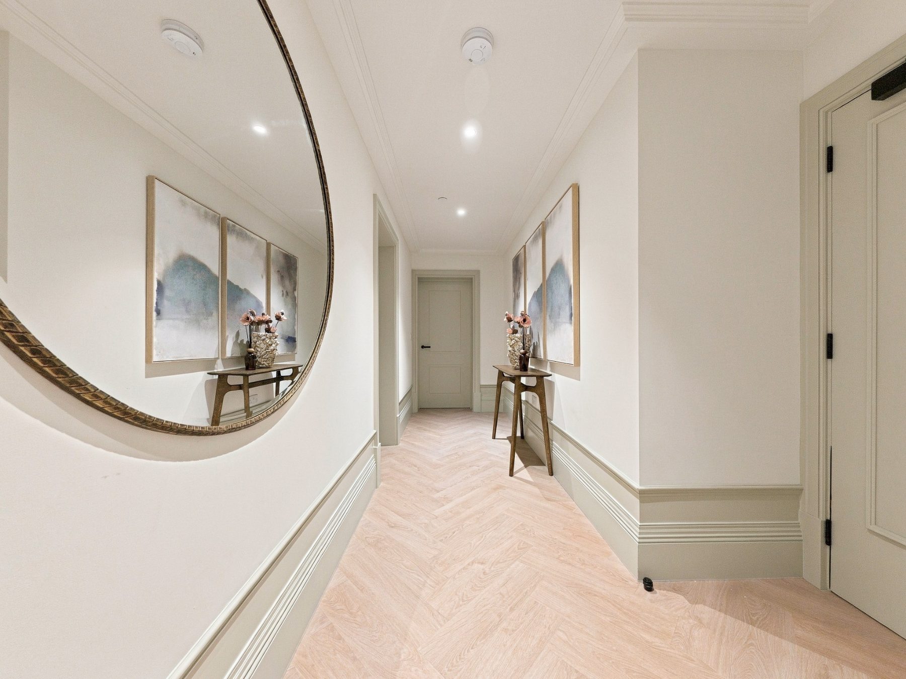 Entrance hallway with herringbone style flooring and moulded doors
