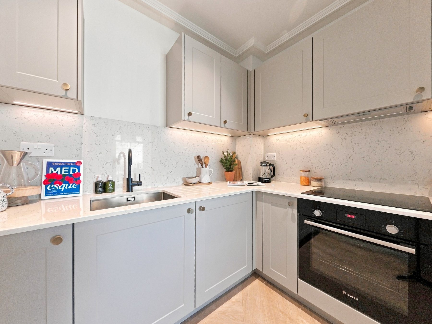 Shaker style kitchen with brushed brass handles and an integrated oven